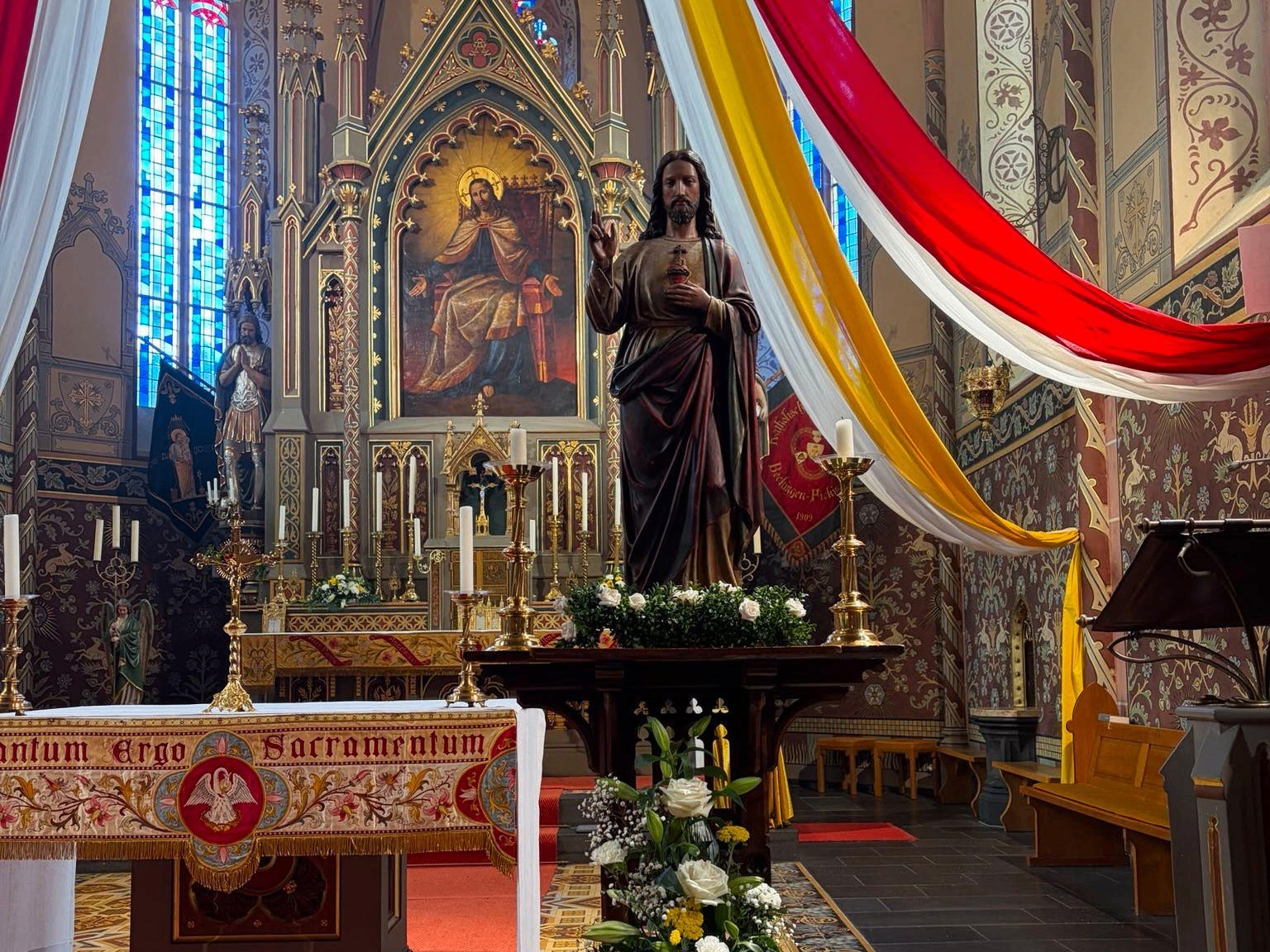 Herz-Jesu-Statue vor festlich geschmücktem Altar